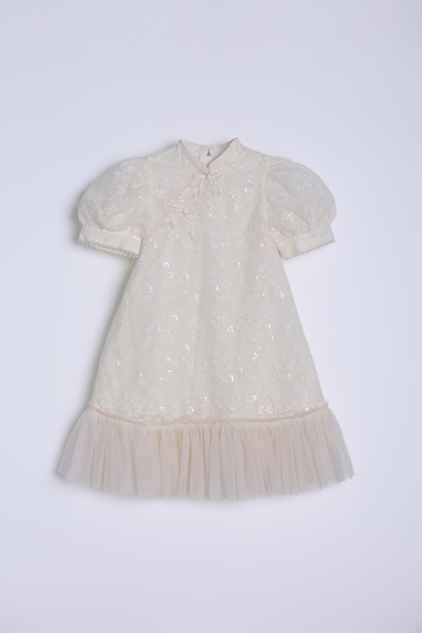 The KIKI and JOJO Puff Sleeve Tulle Cheongsam Dress features pearl-embroidered cuffs, a high neckline, and floral details—perfect as a charming flower girl dress. Laid flat on a white background.