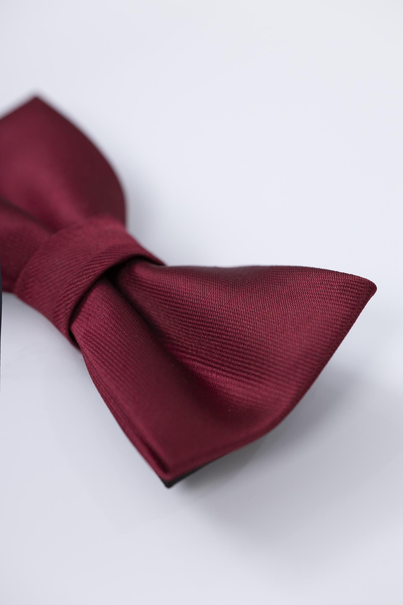 A close-up of the KIKI and JOJO Kids Bow Tie – Pre-Tied Burgundy Satin with an adjustable fit, showcased against a plain light background.