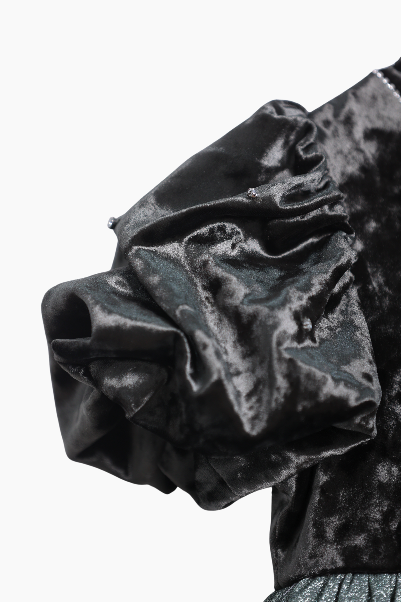 Close-up of the KIKI and JOJO Girls Velvet Puff Sleeve Dress with Rhinestone Trim in forest green, featuring gathered fabric and shimmering accents—ideal for special occasions—shown on a white background.