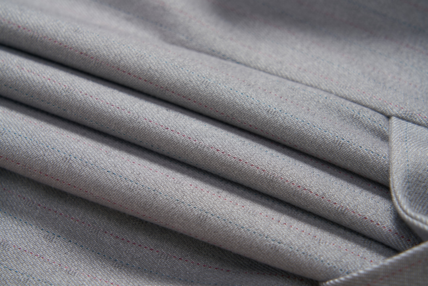 Close-up of the Silver Bloom Suit Vest by KIKI and JOJO: folded light gray fabric with subtle red and blue pinstripes, ideal for a classic boys' formal vest.