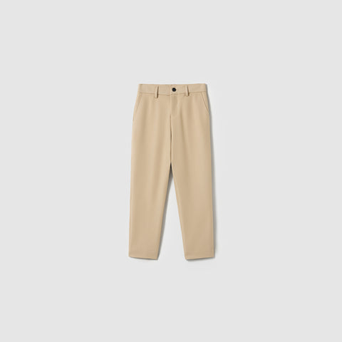 The Savoy Dune Suit Pants by KIKI and JOJO are beige boys' straight-leg dress pants with belt loops, side pockets, an adjustable waistband, and a front button closure, shown on a plain light gray background.