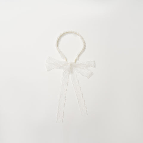 The KIKI and JOJO Girls Pearl Lace Ribbon Headband features white lace, a sweet bow, and long ribbons—an ideal flower girl accessory. Shown on a plain white background.