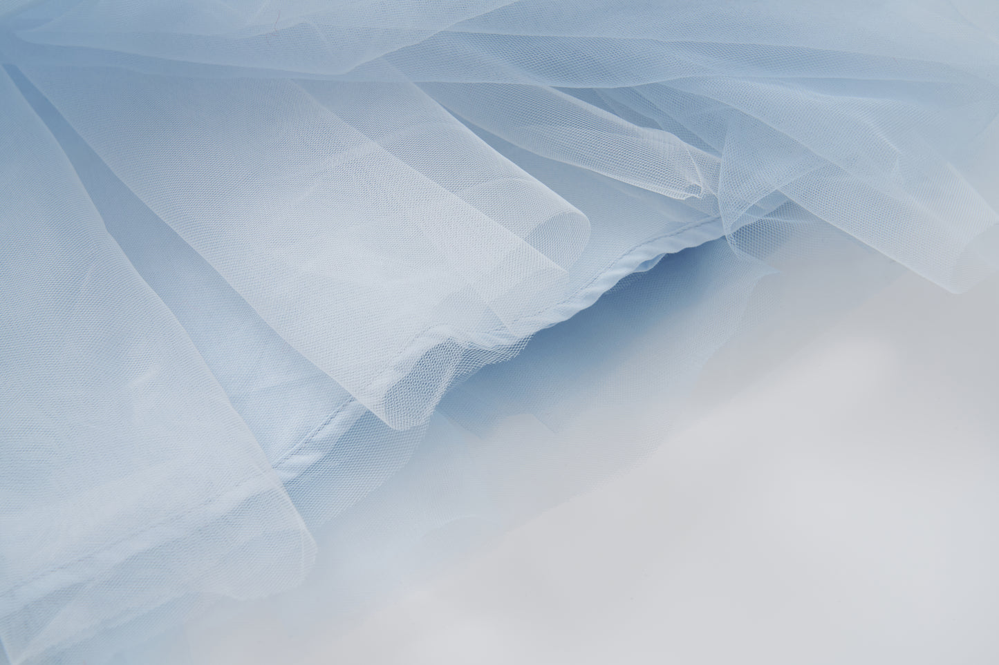 Close-up of the soft light blue tulle from KIKI and JOJO's Sky Whisper Dress, featuring airy folds and delicate layers—perfect for a dreamy puff sleeve look.