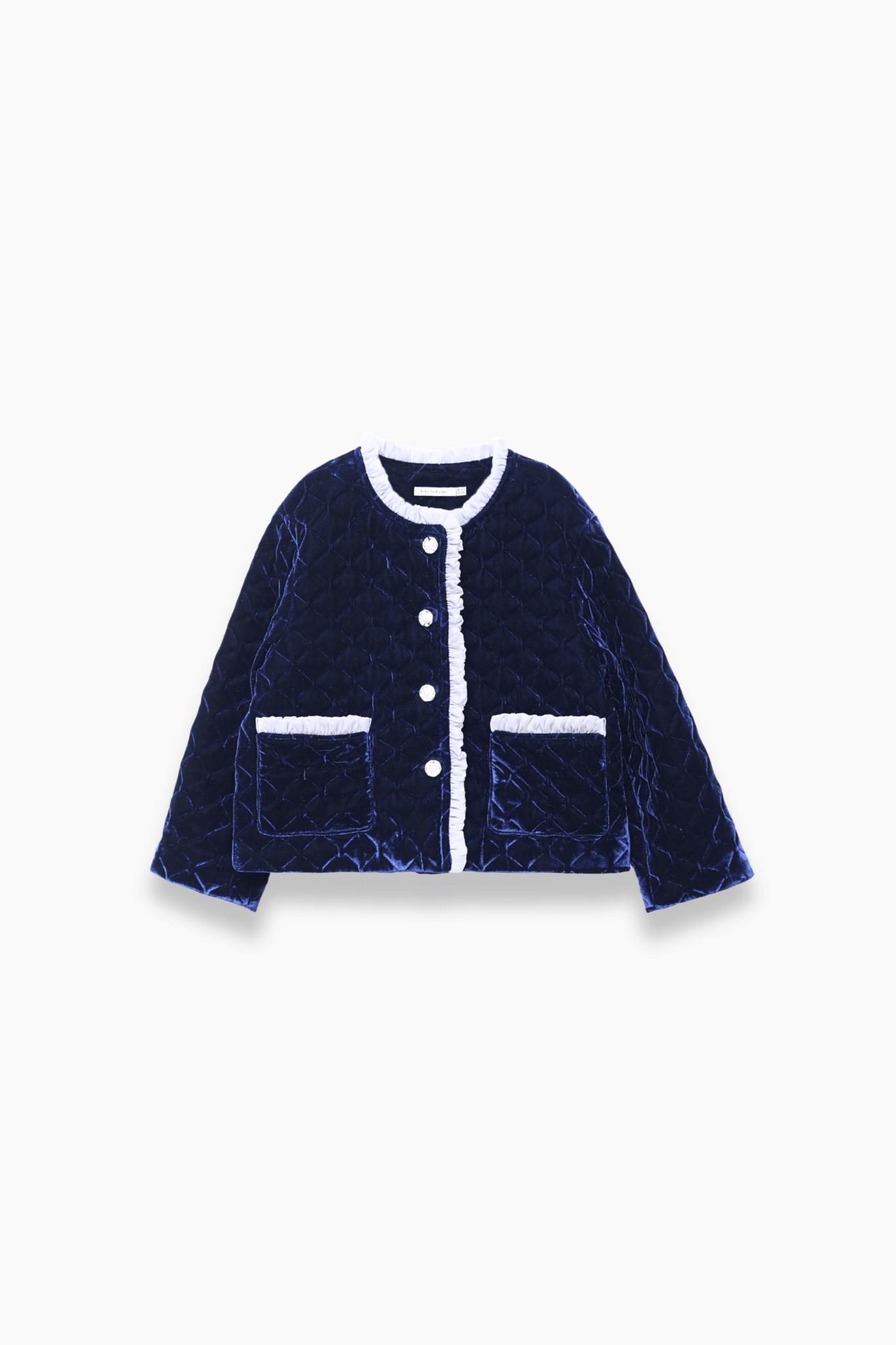 The KIKI and JOJO Girls Quilted Ruffle Jacket in Sapphire Blue features a diamond-quilted design, white trim, petal-shaped buttons, and two front pockets, shown on a plain white background.