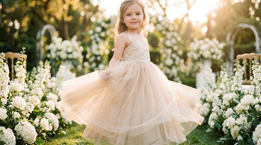 Flower girl twirling in a champagne tutu style tulle dress at a garden wedding