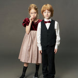 Two children stand side by side in formal attire; the girl wears the KIKI and JOJO Girls Velvet Puff Sleeve Dress with Rhinestone Trim in burgundy red, while the boy sports a suit with a bow tie against a plain background.