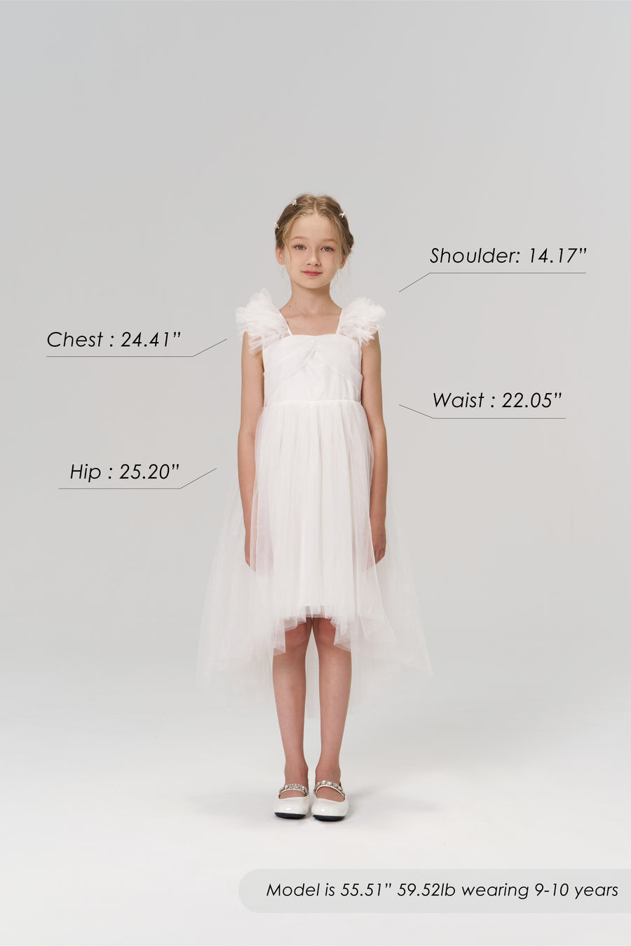 A young girl faces forward in the KIKI and JOJO Cloud Whisper Dress with shoes; her body measurements and model details are labeled around her on a plain light background.