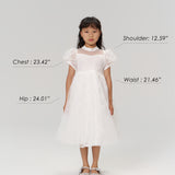 A young girl faces forward in the KIKI and JOJO Whisper Bloom Dress, chest 23.42", shoulder 12.59", waist 21.46", hip 24.01". Model is 47.83" tall, weighs 48lb, and wears size 6-7 years.