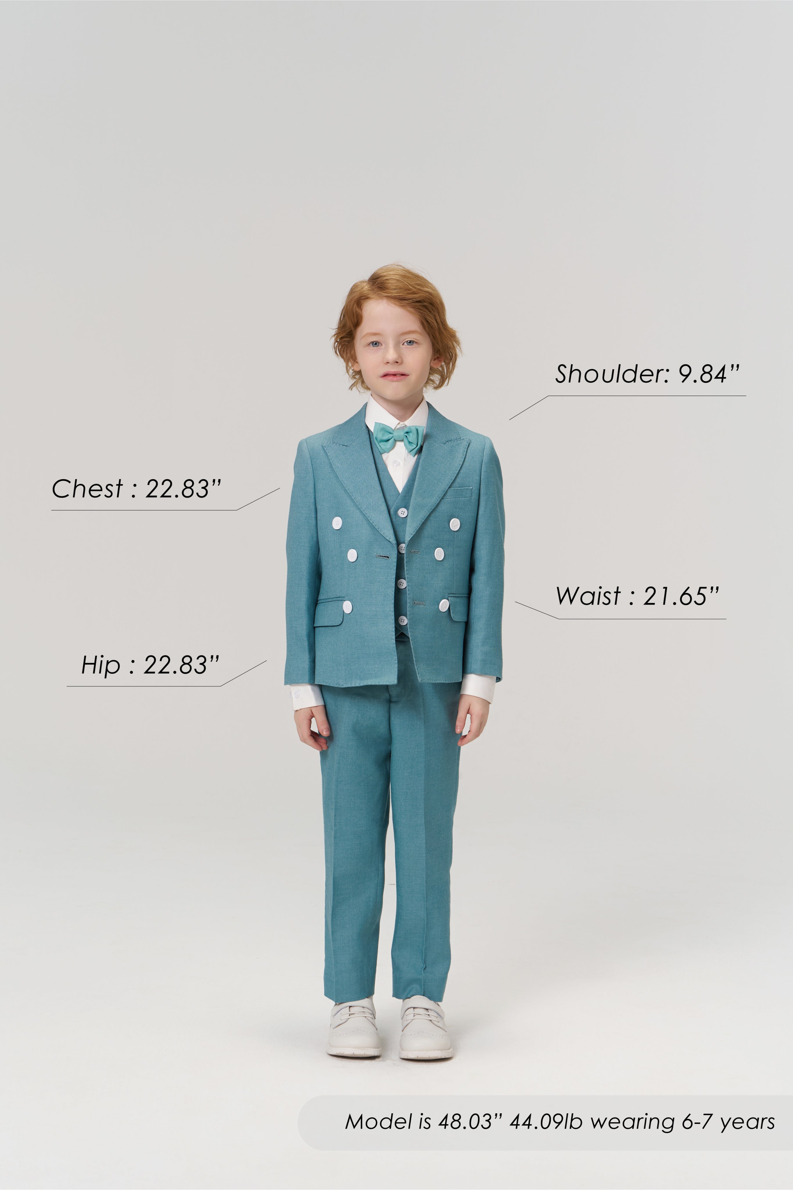 A young child models the Celeste Whimsy Suit Pants by KIKI and JOJO, featuring an adjustable waistband, while size and age details are labeled around him against a plain background.