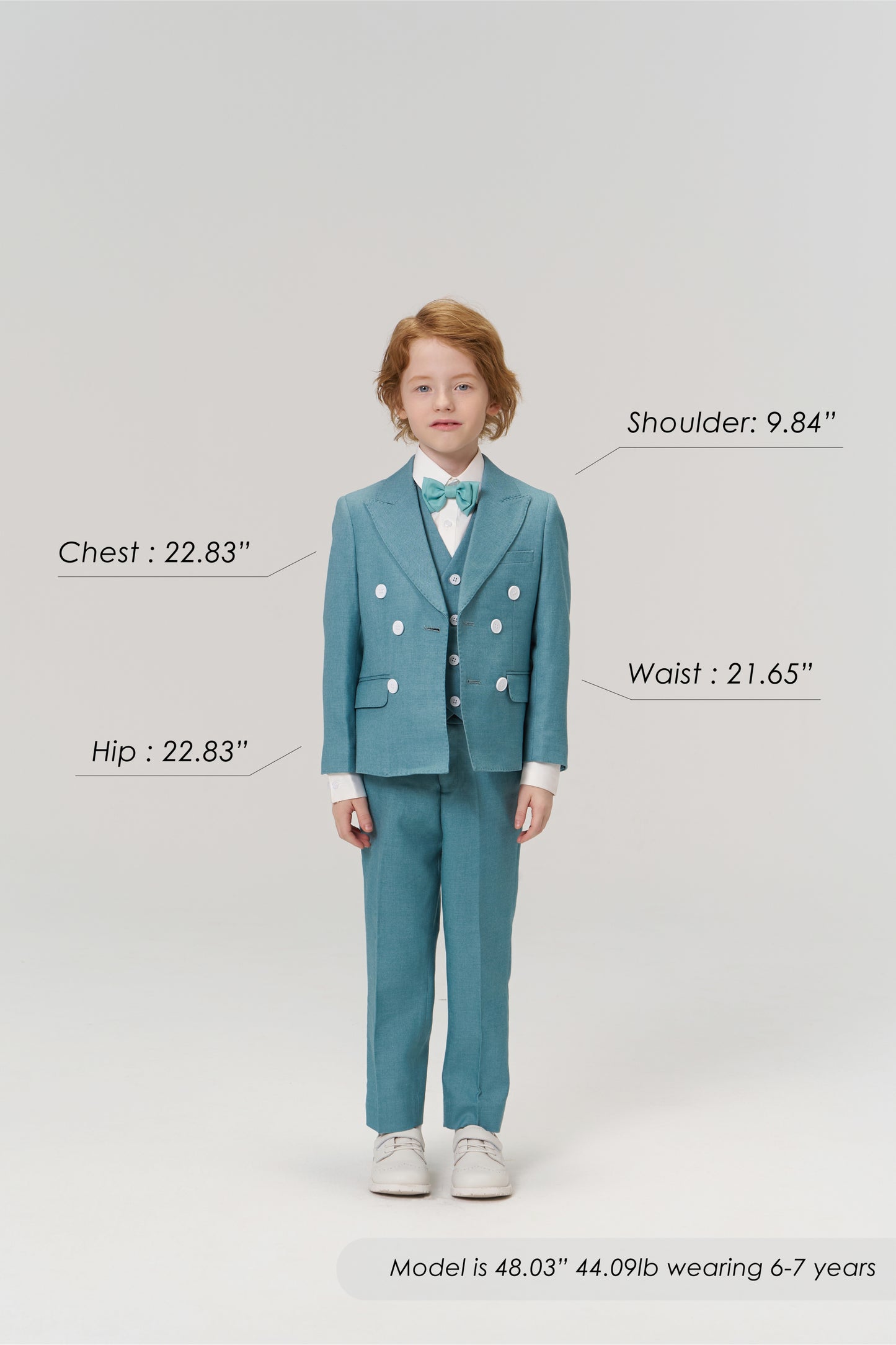 A young child models the Celeste Whimsy Suit Pants by KIKI and JOJO, featuring an adjustable waistband, while size and age details are labeled around him against a plain background.
