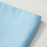 The Radiance Satin Crop Top by KIKI and JOJO, made from light blue liquid-sheen satin, is shown folded on a white surface.