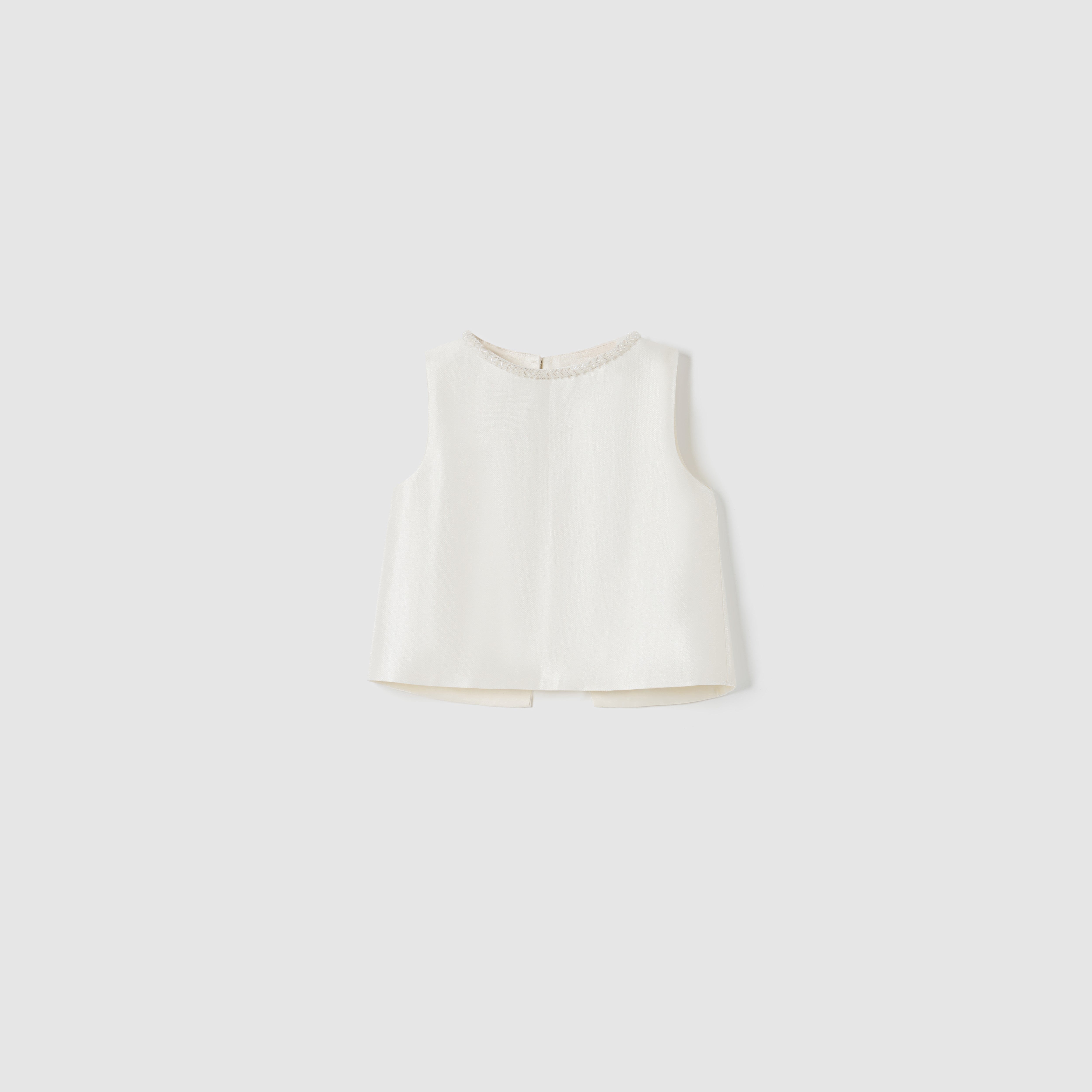 The Radiance Satin Crop Top by KIKI and JOJO is a sleeveless white satin crop top featuring a hand-beaded pearl neckline, shown on a plain light gray background.