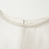 Close-up of the Radiance Satin Crop Top by KIKI and JOJO, showcasing a hand-beaded pearl neckline and small back zipper, displayed on a plain background.