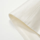 Close-up of the cuff of the cream-colored Radiance Satin Crop Top by KIKI and JOJO, featuring smooth, textured satin fabric and long sleeves, shown against a white background.