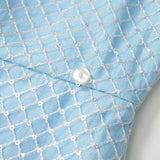 Close-up of the Radiance Sequin Overlay Dress by KIKI and JOJO, featuring light blue fabric with a white lattice pattern and a white button—ideal for convertible dress styles or detachable overskirt designs.