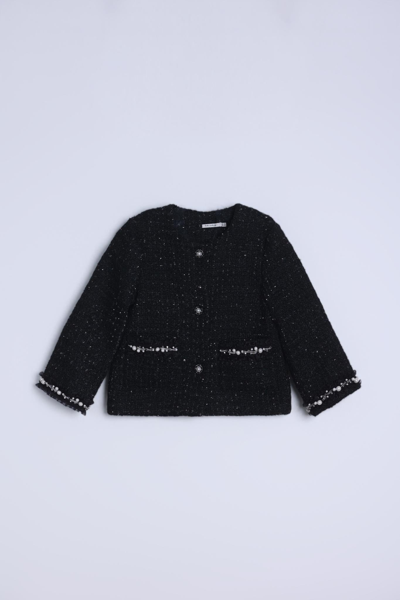 The Girls Tweed Jacket – Classic Black Pearl by KIKI and JOJO is a black, long-sleeve tweed jacket with button-up front, hand-beaded details, front pockets, and decorative trim on a plain light background.