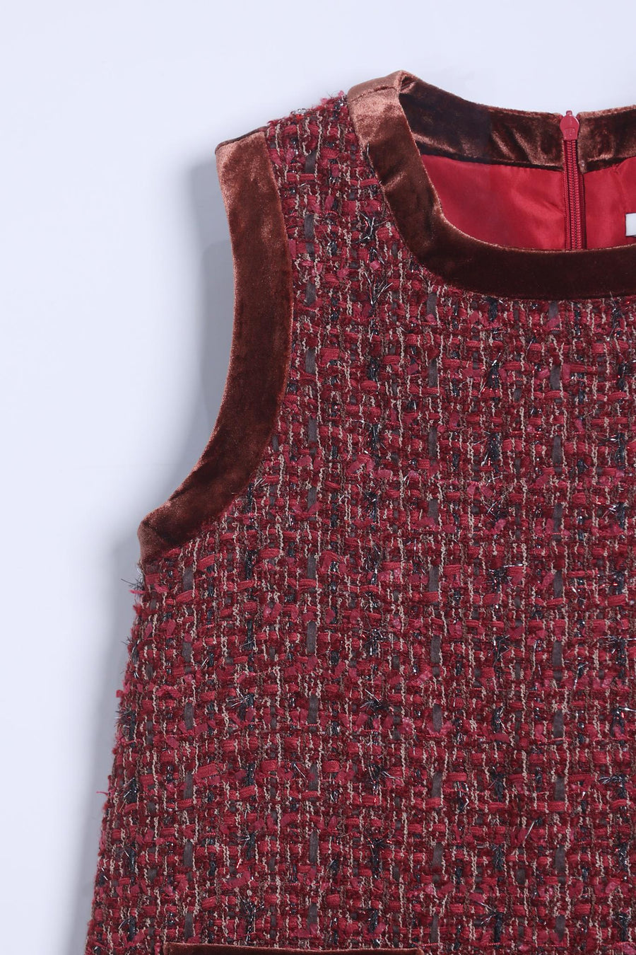 Close-up of the Girls Handmade Tweed Dress – Burgundy Velvet Bow by KIKI and JOJO, showcasing burgundy tweed with velvet trim at the neckline and armhole, back zipper, and detachable velvet bows for a charming finish.