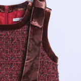 The KIKI and JOJO Girls Handmade Tweed Dress in burgundy features textured fabric, a sleeveless design, velvet trim, a velvet-lined collar, and a wide detachable velvet bow on one shoulder.