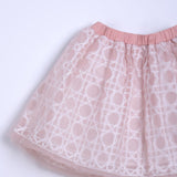 The KIKI and JOJO Girls Tulle Skirt – Darling Blush Pink features a lace-embroidered overlay with white geometric patterns and a solid elastic waistband, shown against a plain light background.