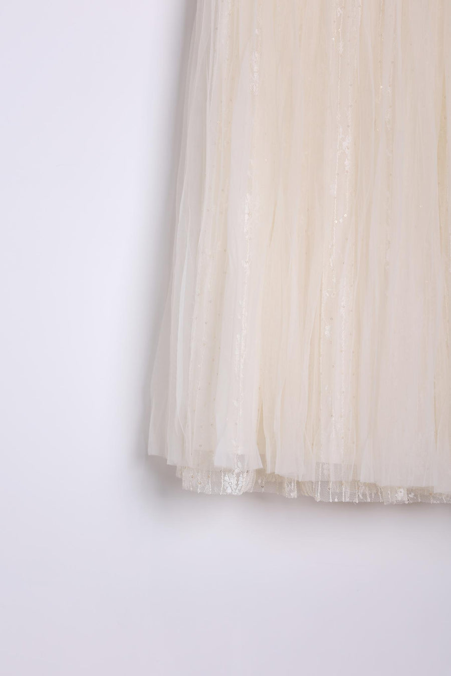 Close-up of the KIKI and JOJO Girls Dreamy Sequined Tulle Skirt, featuring cream-colored tulle with subtle shimmer accents and a silver satin waistband, shown against a plain white background.