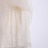 Close-up of the KIKI and JOJO Girls Dreamy Sequined Tulle Skirt, featuring white layered fabric with sheer tulle over sequin-embroidered lace, adorned with vertical lines of sequins and beads.