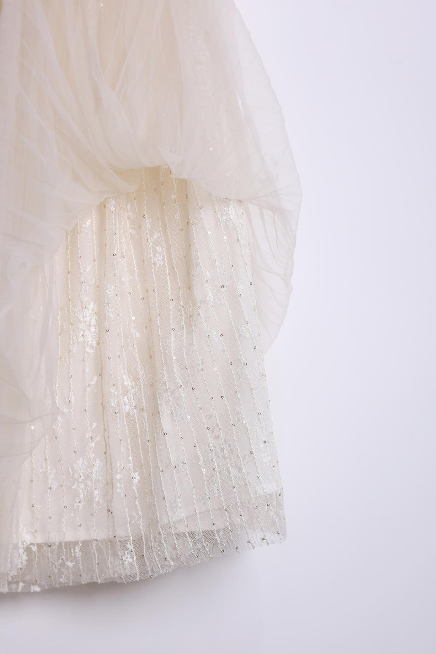 Close-up of the KIKI and JOJO Girls Dreamy Sequined Tulle Skirt, featuring white layered fabric with sheer tulle over sequin-embroidered lace, adorned with vertical lines of sequins and beads.