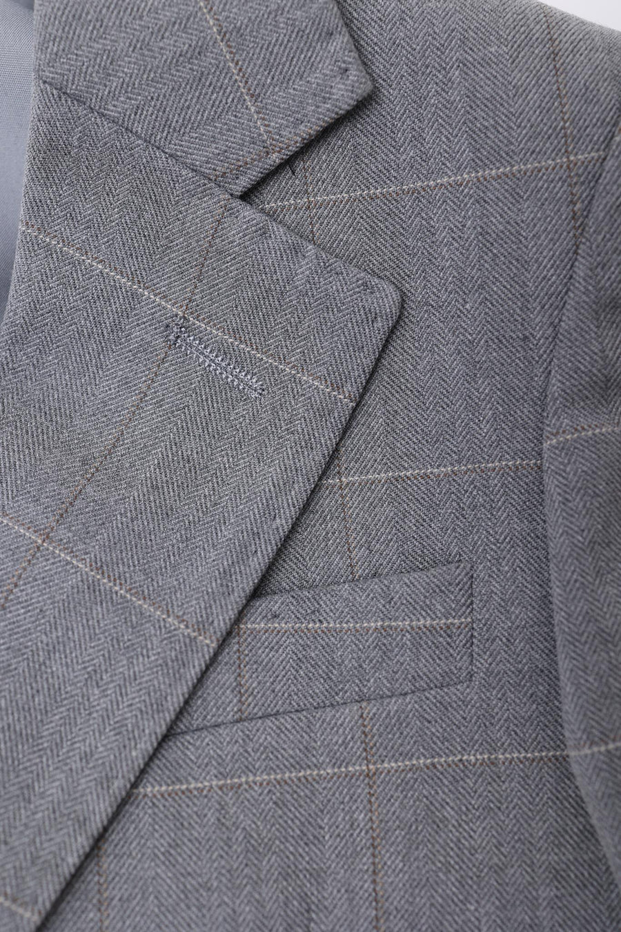 Close-up of the KIKI and JOJO Kids Suit Jacket in light gray, checkered, wrinkle-free fabric with notched lapel and chest pocket. Suitable for ages 3-14 years.