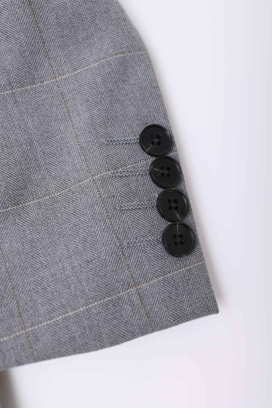 Close-up of the KIKI and JOJO Kids Suit Jacket in Light Gray (3-14 Years), featuring a checkered pattern and four black cuff buttons, crafted from wrinkle-free fabric.