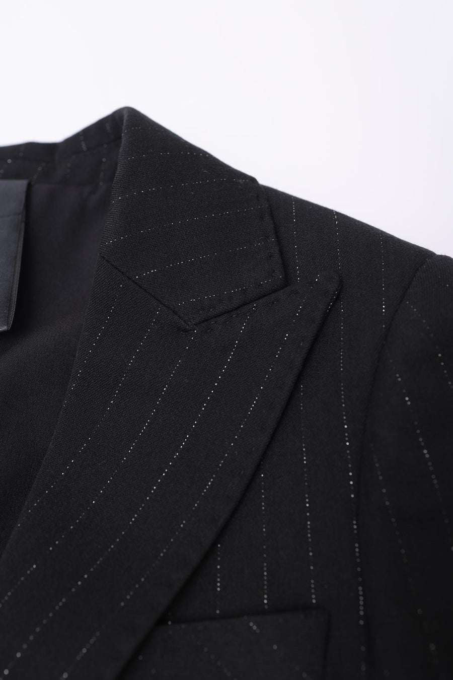 Close-up of the KIKI and JOJO Kids Suit Jacket – Black (3-14 Years), Classic Fit, with subtle white pinstripes, notched lapel, and part of the lining. Made from wrinkle-free fabric for lasting style and comfort.