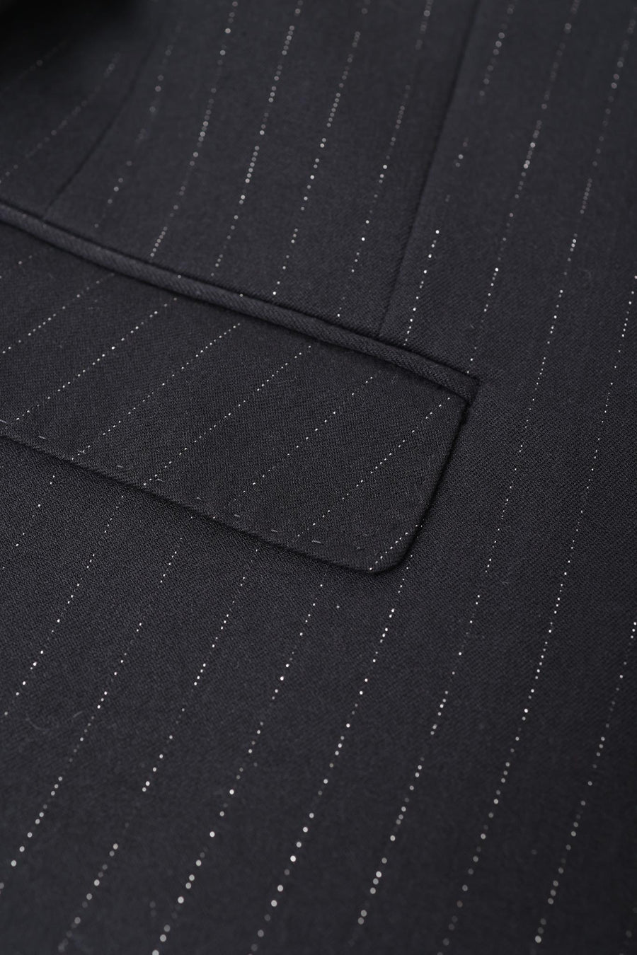 Close-up of the KIKI and JOJO Kids Suit Jacket – Black (3-14 Years) in classic fit, made from wrinkle-free fabric with fine white pinstripes and a flap pocket detail.