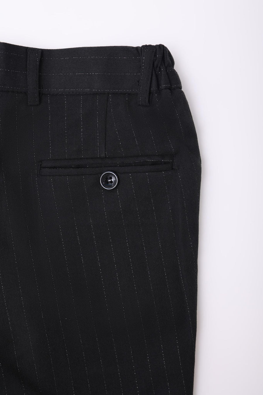 Close-up of KIKI and JOJO Kids Suit Pants – Black (3-14 Years), Classic Fit, wrinkle-free, with pinstripes, flat front, waistband with belt loops, and a single buttoned back pocket.