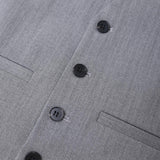 Close-up of the KIKI and JOJO Kids Suit Vest – Gray (3-14 Years), featuring a wrinkle-free, classic fit in herringbone fabric with four black buttons and two welt pockets for a tailored look.
