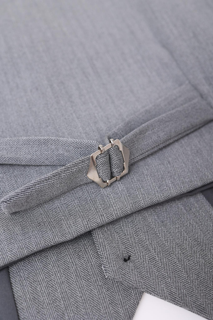 Close-up of a gray herringbone fabric belt with a silver buckle, part of the KIKI and JOJO Kids Suit – Gray 3-Piece Set (Classic Fit, Wrinkle-Free) for ages 3-14.