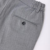 Close-up of the back pocket on KIKI and JOJO Kids Suit Pants – Gray (3-14 Years), featuring a classic fit, single buttoned pocket, elastic waistband, and wrinkle-free fabric.