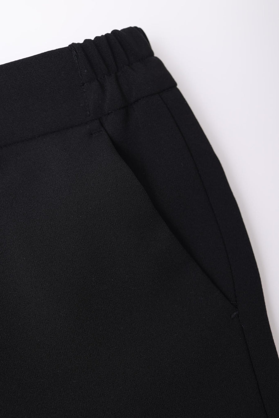 Close-up of black pants with an elastic waistband and side pocket from the KIKI and JOJO Kids Suit – Black 2-Piece Set (3-14 Years), Slim Fit, Wrinkle-Free—ideal for a polished look.
