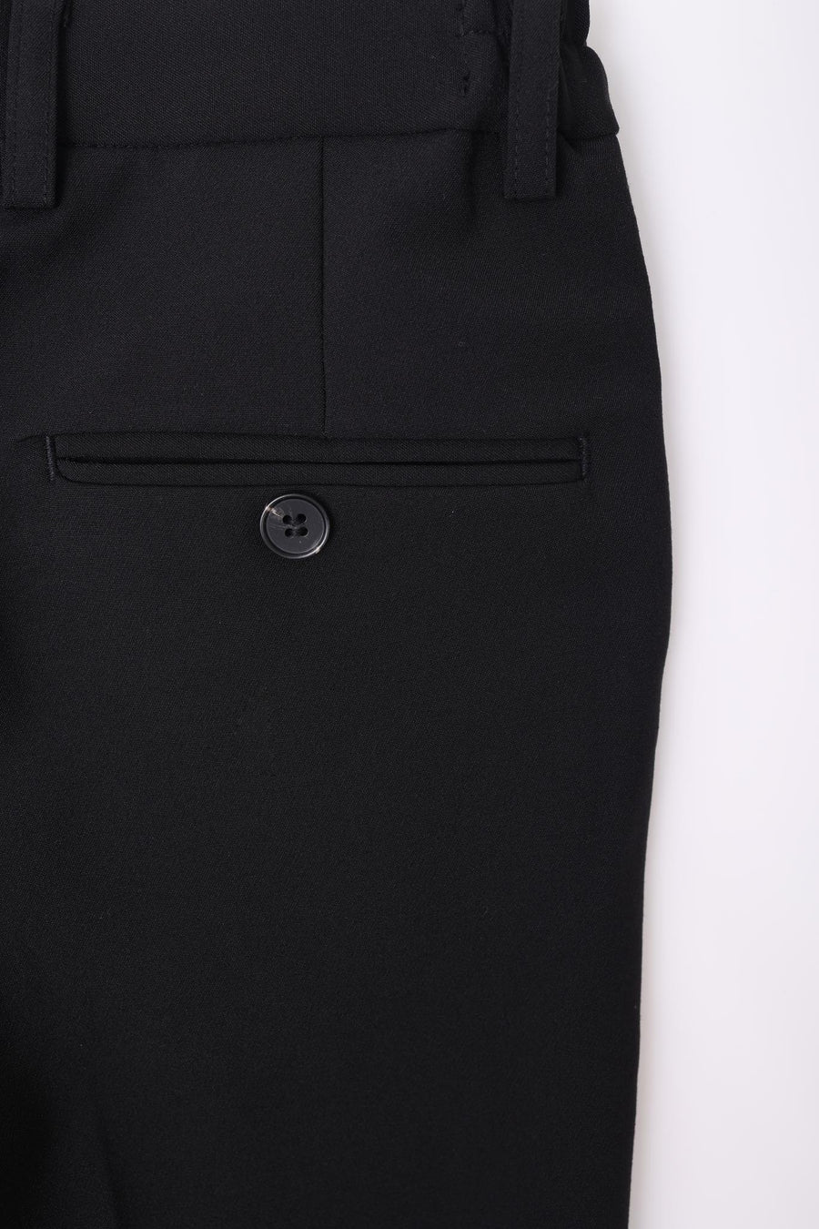 Close-up of a KIKI and JOJO Kids Suit – Black 2-Piece Set (3-14 Years), Slim Fit, Wrinkle-Free pant pocket with a single button and belt loops, shown against a plain white background.
