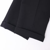Two pairs of KIKI and JOJO Kids Suit Pants – Black (3-14 Years), slim-fit and wrinkle-free, are laid side by side on a white background.