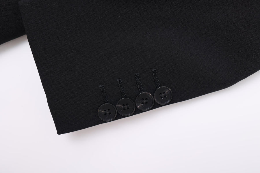 Close-up of the cuff on the KIKI and JOJO Kids Suit – Black 2-Piece Slim Fit (3-14 Years), showing four black buttons sewn in a row; made with wrinkle-free fabric for a sharp look.