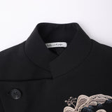 Close-up of the KIKI and JOJO Kids Suit Jacket – Black (3-14 Years), a slim-fit, wrinkle-free design featuring a Classic Mandarin collar, black button, mountain embroidery, and the brand’s inner label.