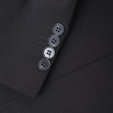 Close-up of the KIKI and JOJO Kids Suit Jacket – Black (3-14 Years), featuring four black buttons on the cuff. This slim-fit, wrinkle-free jacket is displayed against a matching black background.