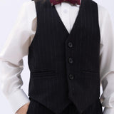 A young boy wears a white dress shirt, black pinstripe vest and pants, and a KIKI and JOJO Kids Bow Tie – Burgundy Bear – Pre-Tied Satin – Adjustable, with one hand in his pocket.