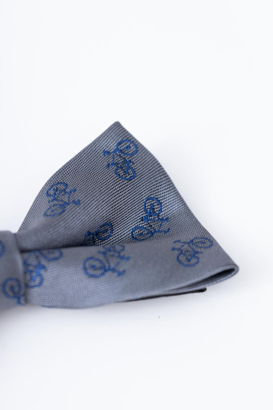 The KIKI and JOJO Kids Bow Tie – Light Gray Bicycle is a pre-tied, adjustable satin bow tie featuring a charming repeating blue bicycle pattern for stylish kids' outfits.