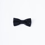The KIKI and JOJO Kids Bow Tie features a black satin fabric with white dots, pre-tied for convenience and adjustable for comfort; displayed against a plain white background, it pairs perfectly with any kids dress shirt.