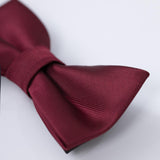 A close-up of the KIKI and JOJO Kids Bow Tie – Pre-Tied Burgundy Satin with an adjustable fit, showcased against a plain light background.
