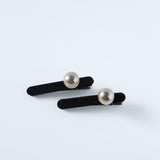 KIKI and JOJO Girls Pearl Hair Clips – Set of Two – Black Velvet, featuring hand-crafted round pearl embellishments, rest on a plain white surface.