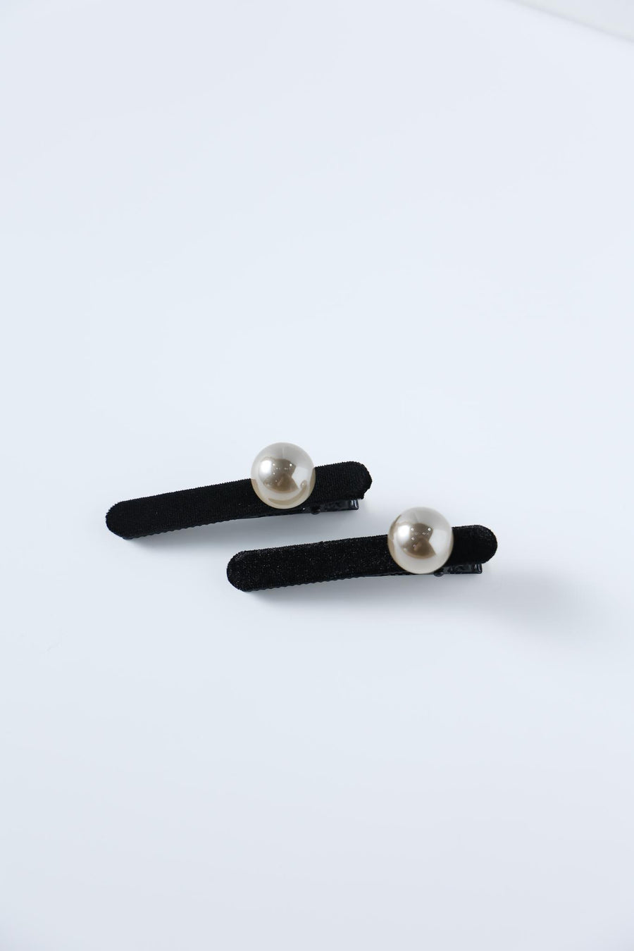 KIKI and JOJO Girls Pearl Hair Clips – Set of Two – Black Velvet, featuring hand-crafted round pearl embellishments, rest on a plain white surface.