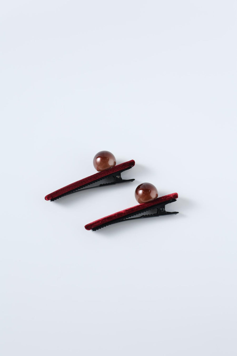 Set of 2 Girls Pearl Hair Clips by KIKI and JOJO, featuring black handcrafted clips with burgundy velvet trim and a round brown bead, displayed on a light gray background.