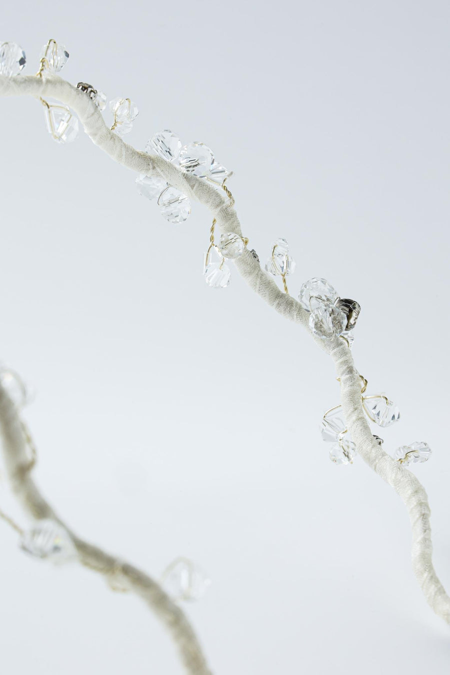 A close-up of the KIKI and JOJO Beaded Flower Girl Headband, featuring gold wire-wrapped branches with translucent crystal-like beads resembling delicate flowers, set against a light background.