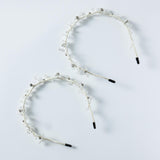 Two KIKI and JOJO Beaded Flower Girl Headbands – Gold Wire-Wrapped, adorned with small beaded flowers and black-tipped wire loops, are arranged side by side on a light gray surface.