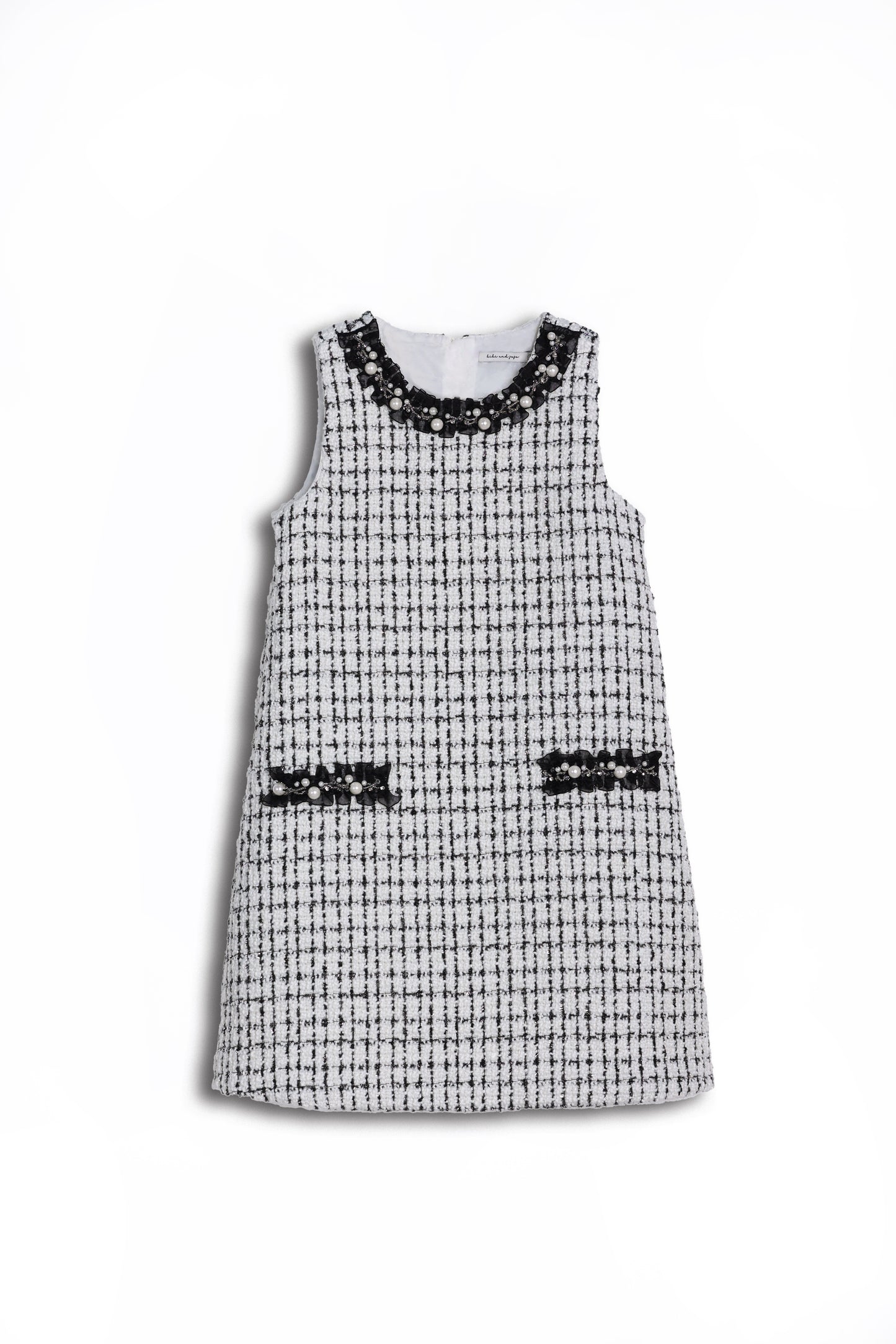 KIKI and JOJO’s Girls Tweed Dress in black & white checkered pearl features a sleeveless design, two front pockets, and a pearl-adorned neckline—ideal for special occasions, shown on a white background.